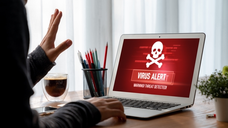 an image depicting a virus alert on a laptop